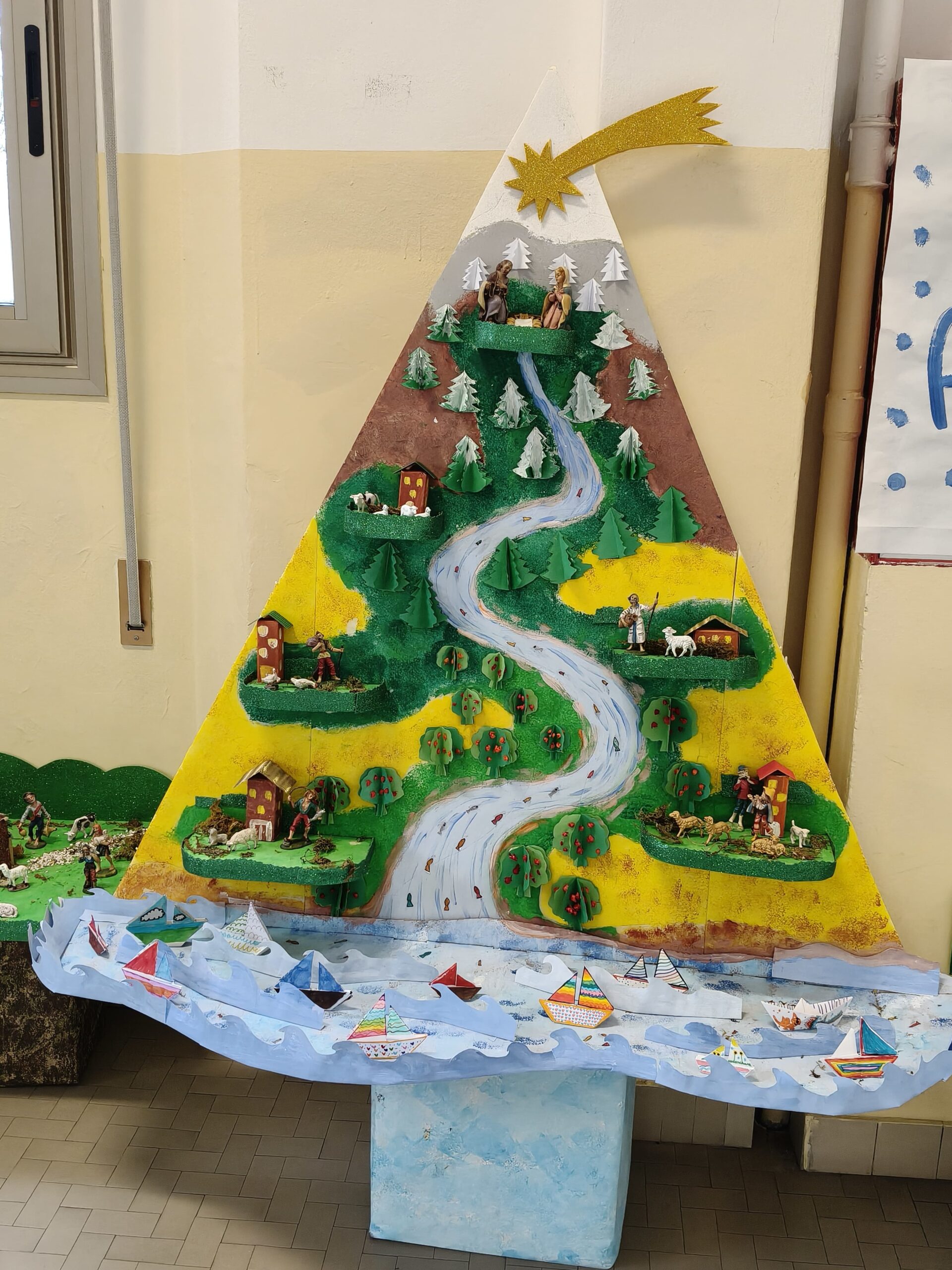 Un albero di Natale realizzato in cartone, attraversato da un fiume