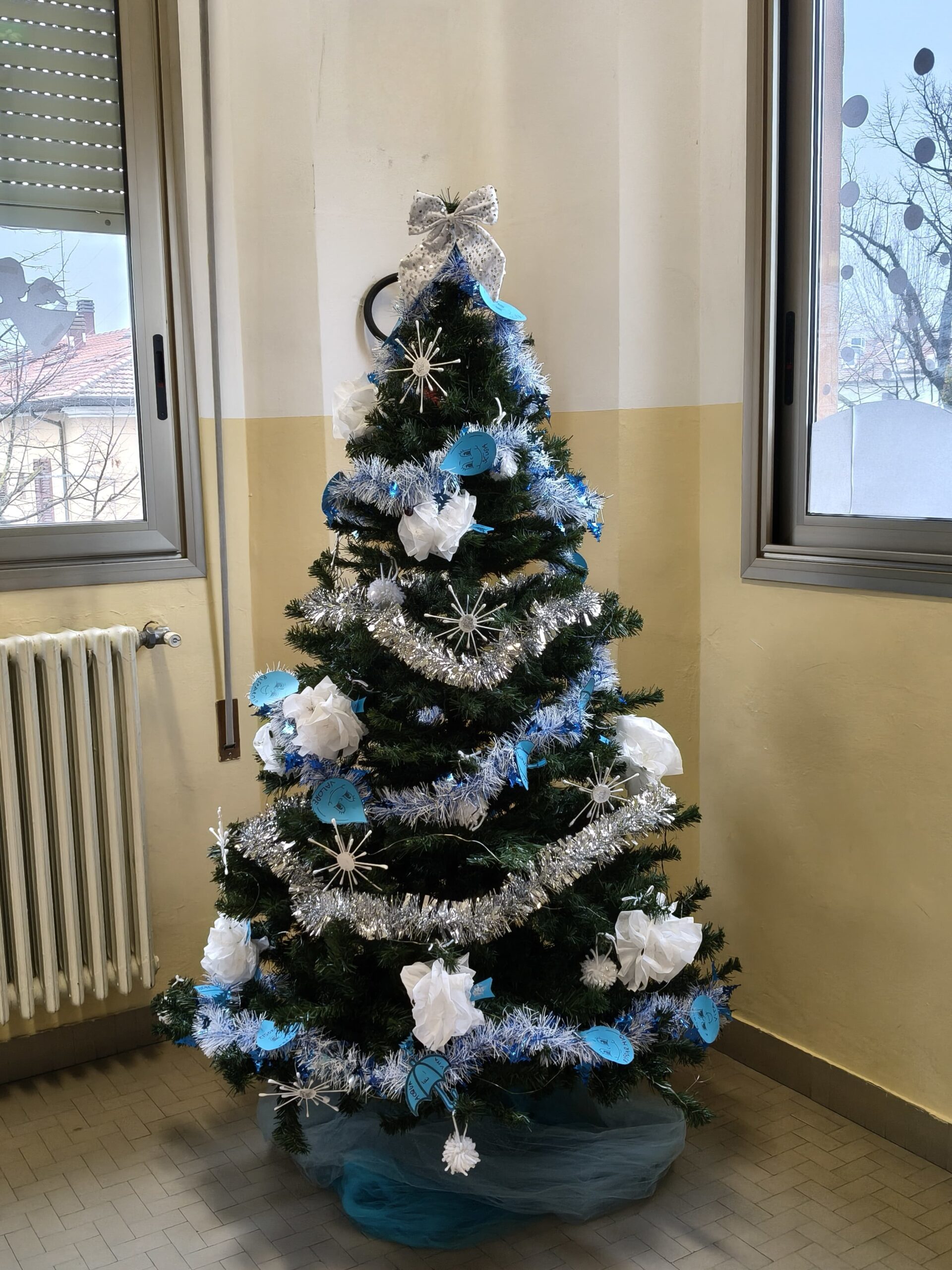 Un albero di Natale con decorazioni bianche e azzurre.