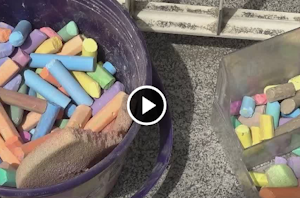 Due secchi contenenti gessi colorati che gli alunni hanno usato per disegnare sull'asfalto di fronte alla scuola - link al video del servizio realizzato da IcaroTv